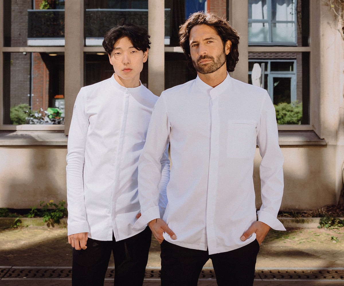 Two chefs in white chef jackets outside a restaurant
